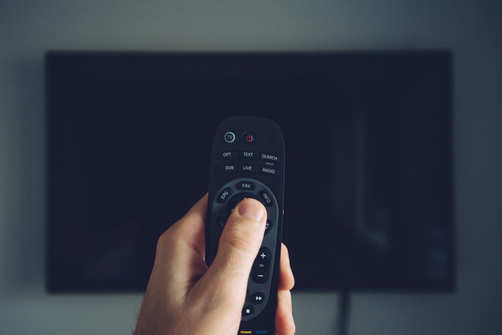 Male hand with TV remote controller