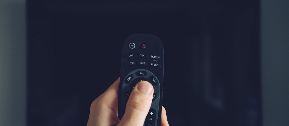 Male hand with TV remote controller